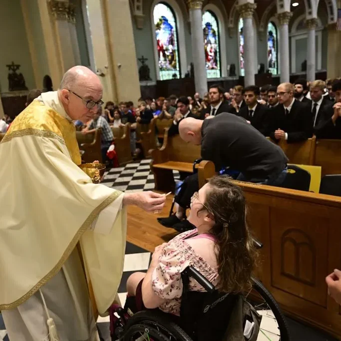 Bishop Timothy Senior gives Holy Communion to a young woman during the celebration of Mass.